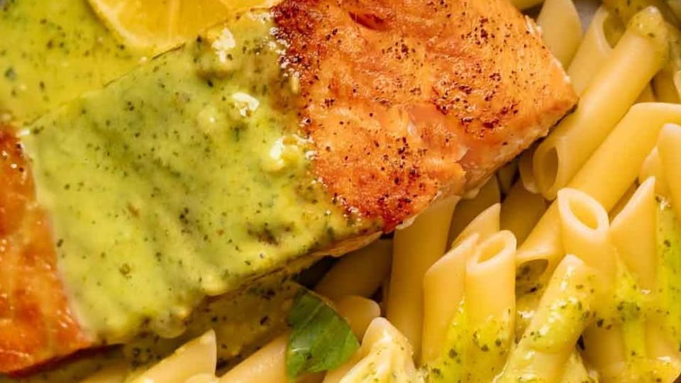 Grilled salmon with lemon herb sauce served with penne pasta.
