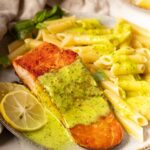 Salmon and Pesto Pasta with basil leaves.