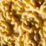 Creamy macaroni and cheese with rich, gooey cheddar sauce, capturing the classic comfort food close-up.