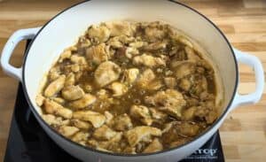 Chicken stew cooking in a pot on a stovetop, with rich sauce and tender pieces of meat. Perfect for hearty meals.