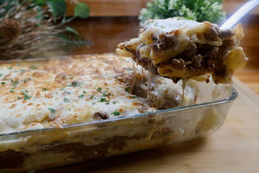 Delicious baked lasagna with cheesy layers being served from a glass dish.