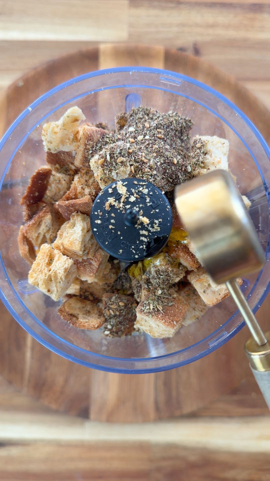 Bread cubes and spices inside a food processor.