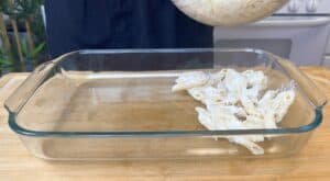 Preparing creamy pasta in a glass baking dish for a delicious homemade meal.