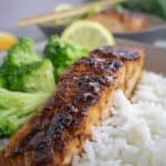 Grilled salmon with steamed broccoli and jasmine rice, garnished with lemon for a healthy meal.