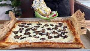 Freshly baked mushroom tart on a baking tray with a golden crust and melted cheese.