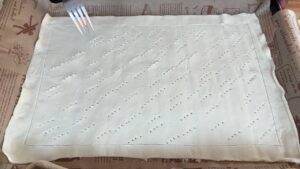 Pastry dough with fork pricks on parchment paper, ready for baking.