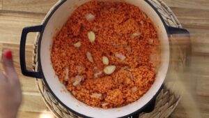 Cooking red lentils with garlic and onions in a large pot for a delicious meal preparation.