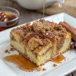 Delicious cinnamon coffee cake drizzled with honey on a white plate, perfect for breakfast or a sweet treat.
