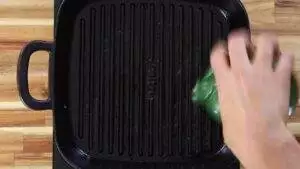 Hand seasoning a grill pan with oil for a non stick cooking surface.