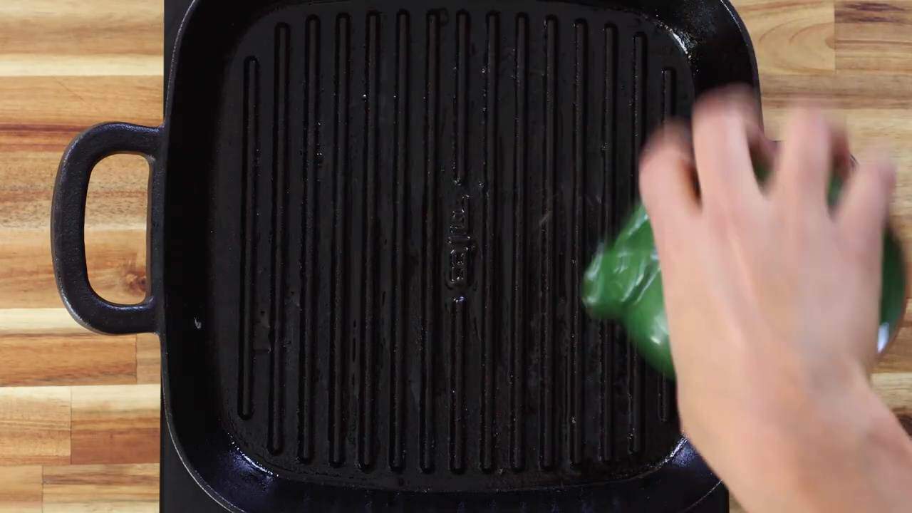 Hand seasoning a grill pan with oil for a non stick cooking surface.