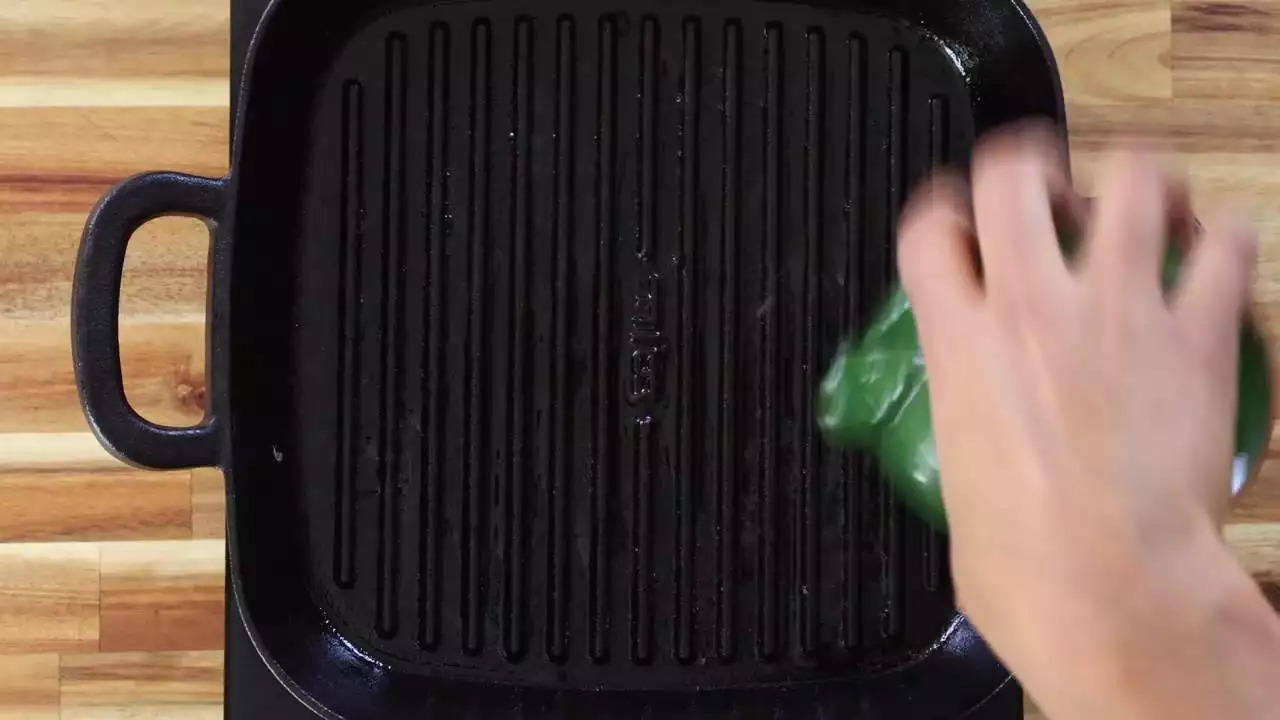 Hand seasoning a grill pan with oil for a non stick cooking surface.