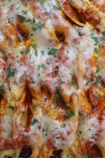 Cheesy baked pasta shells with tomato sauce and parsley garnish, perfect Italian comfort food dish.