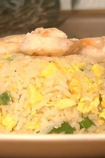 Delicious shrimp fried rice with eggs and green onions on a plate, perfect for a tasty Asian-inspired meal.