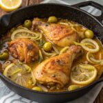 poulet yassa with olives and lemon slices in a black pot.