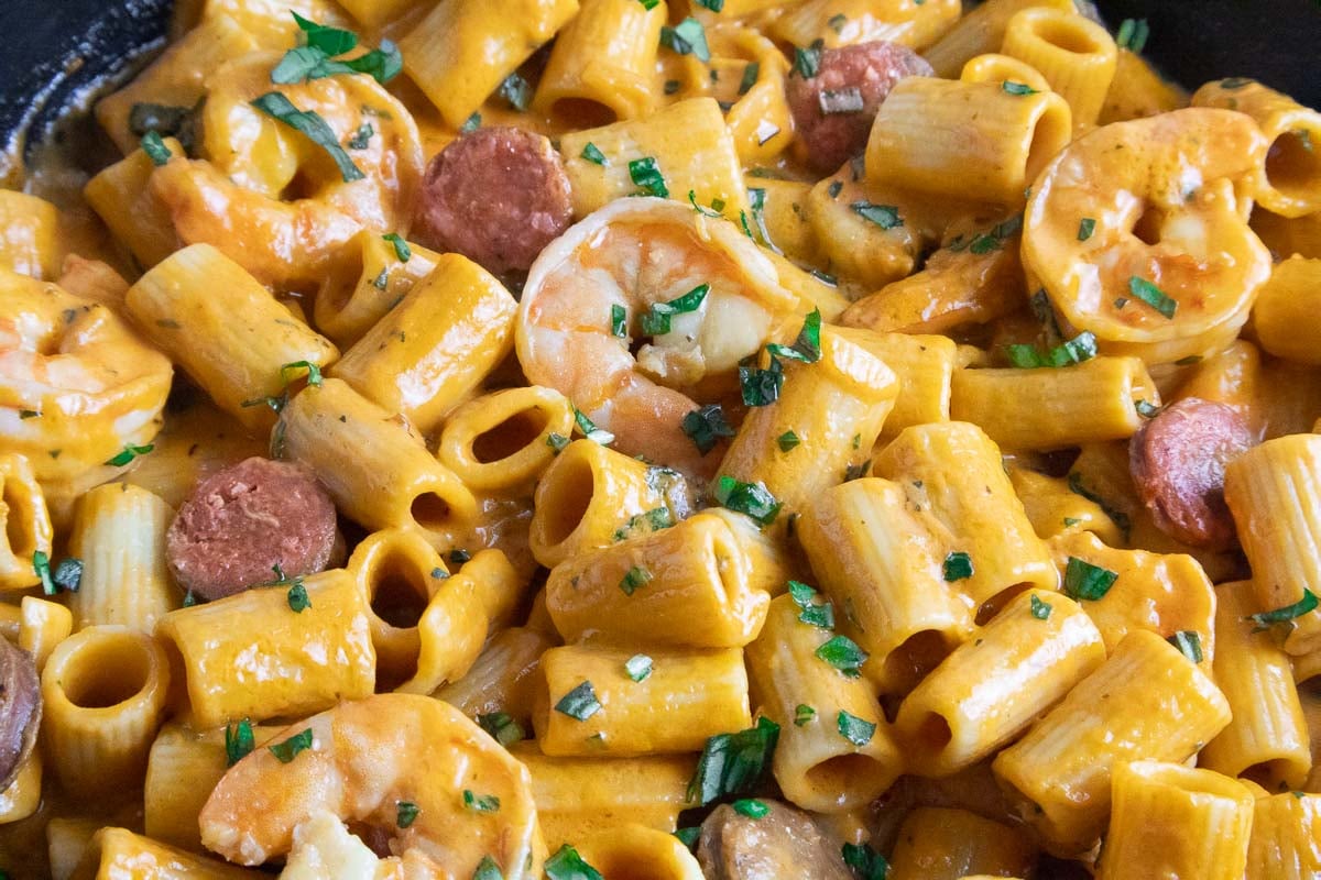 Creamy prawn and chorizo pasta garnished with fresh herbs.