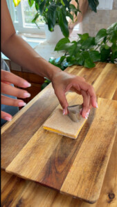 Hands placing a cookie cutter heart onto bread.