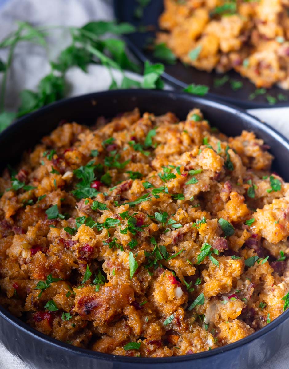 Savory Chicken chorizo and stuffing casserole with herbs, served in a black bowl, garnished with fresh parsley.