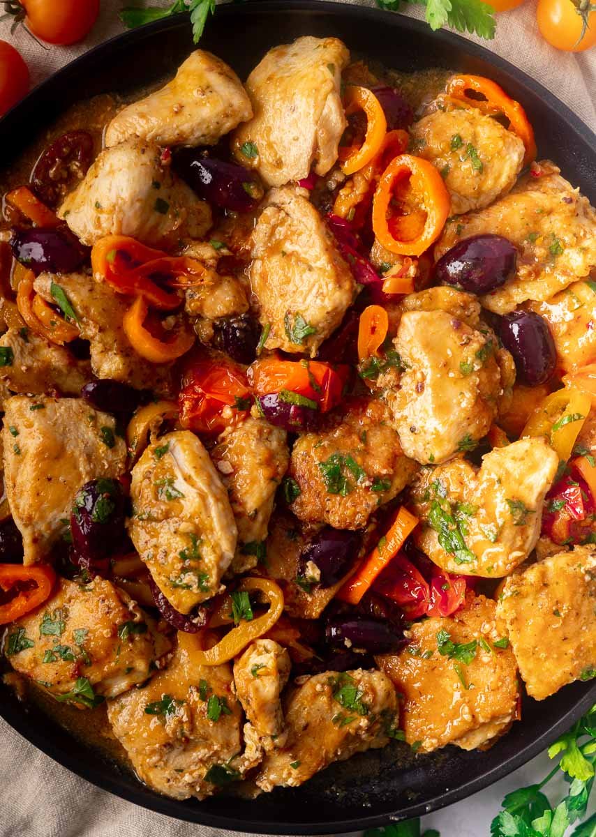 Mediterranean chicken and peppers and herbs in a skillet.