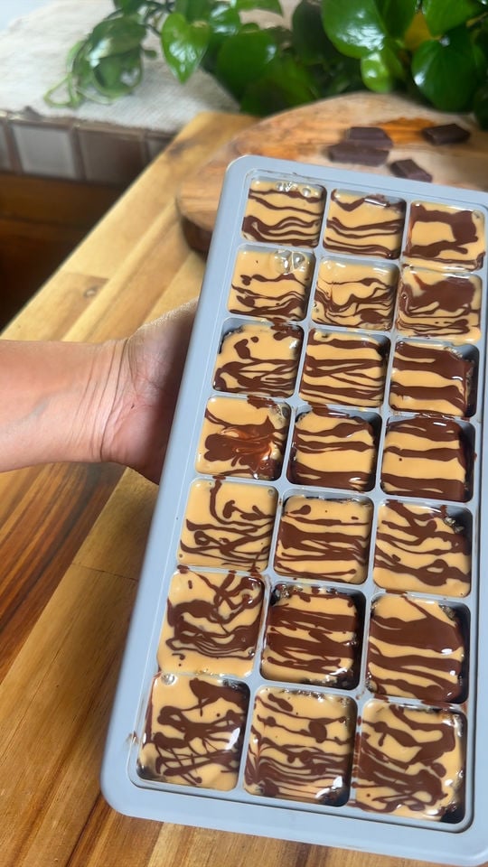 Hand holding a tray of samoas and chocolate swirl squares.