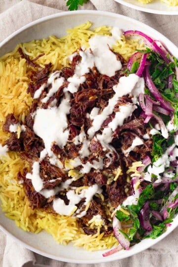 Spiced braised chuck roast, creamy sauce, and a side of red onion and parsley salad.