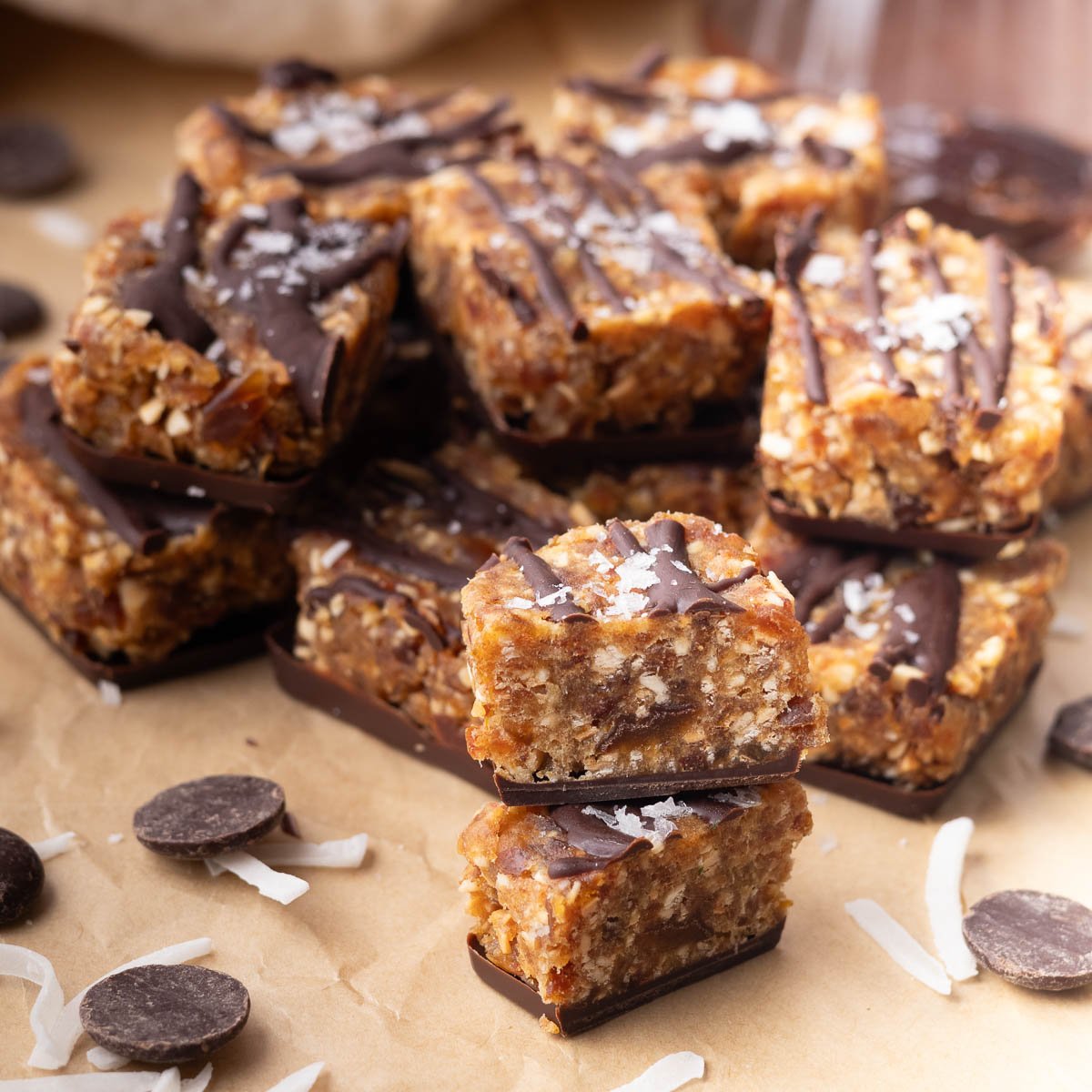 Stack of samoas cookie bites with coconut flakes on brown paper.