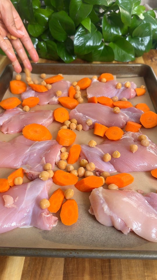 Chopped chicken, carrots, and chickpeas on a baking sheet.