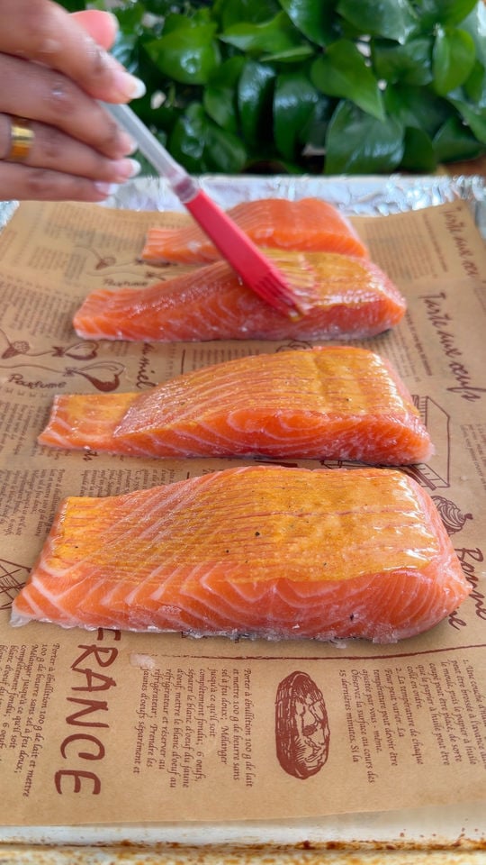 Hand brushing rub on salmon fillets.