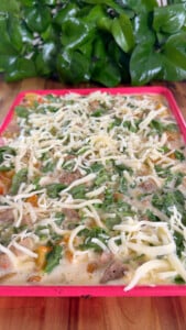 egg mixture with cheese, spinach, and sausage on a pink tray.