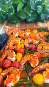 Grilled shrimp with cherry tomatoes and asparagus on a tray.