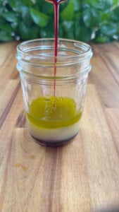 Pouring sauce ingredients into jar.