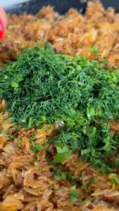 Chopped herbs on a dish with rice and minced meat.
