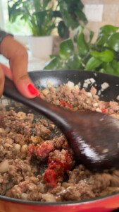 Cooking ground beef, tomato paste and onions in a pan