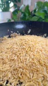 Close-up of orzo pasta in a pan.