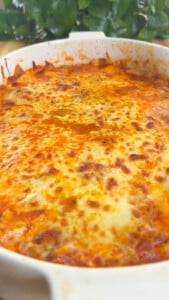Baked cheesy dish in a white casserole, with golden-brown top.