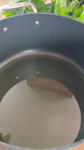 Large black pot with oil inside on a kitchen counter.