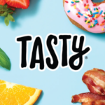 Tasty logo with strawberry, donut with sprinkles, bacon, basil, and orange slice on a blue background.