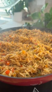 Steaming pan of stuffed pepper bowl with rice, peppers and meat.