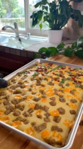Sheetpan pancakes with sausage and cheese in kitchen.