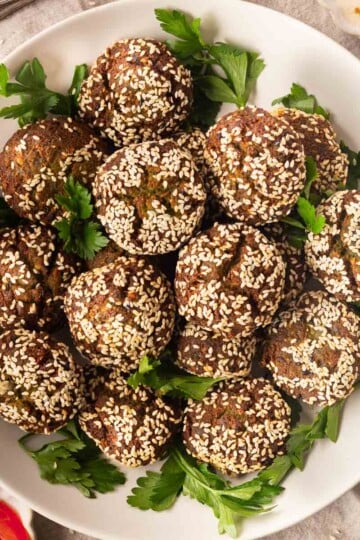 Plate of crispy homemade falafel balls garnished with fresh parsley.