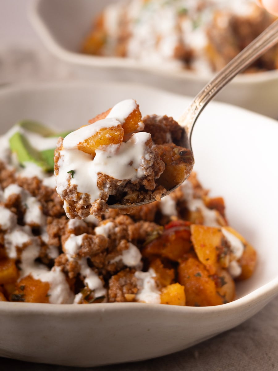 Close-up of Lebanese potato bowl with creamy sauce in a white bowl.