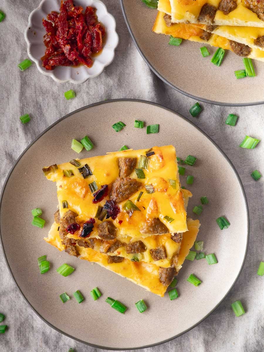Sheet pan savory pancakes on a plate with scallions.