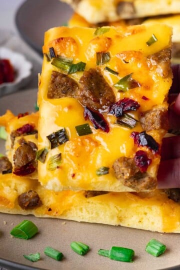 Sheet pan savory pancakes with sausage, cranberries, and herbs on a plate.