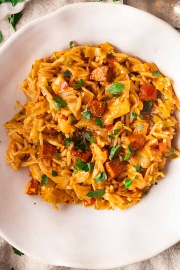 Mediterranean Dirty Cabbage with tomato sauce, parsley, and cubed vegetables on a plate.
