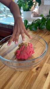 Meat in a glass bowl with bulghur and spices on top.
