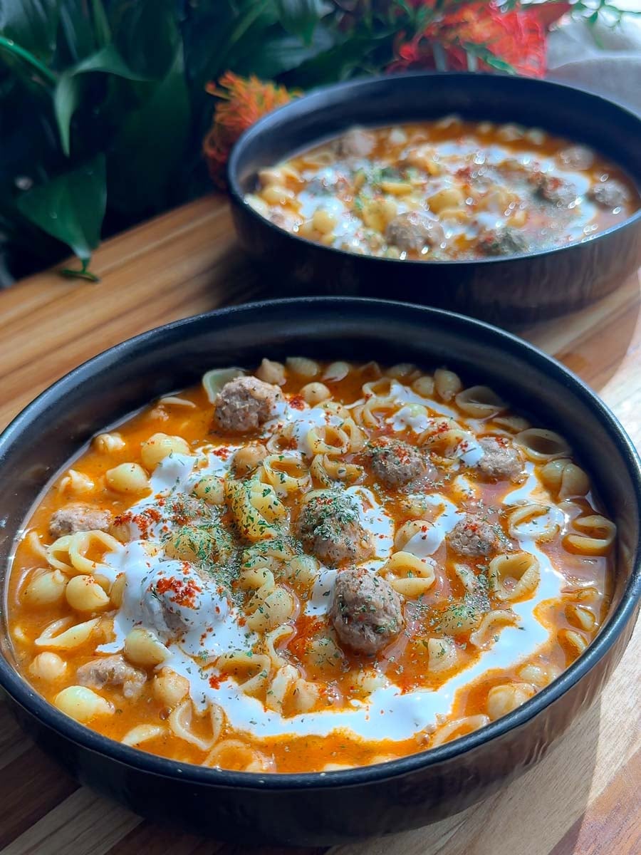 Armenian meatball soup with pasta shells with meatballs in creamy tomato sauce in black bowls