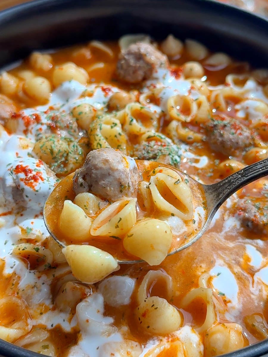Armenian meatball soup in tomato sauce with meatballs and cream in a bowl
