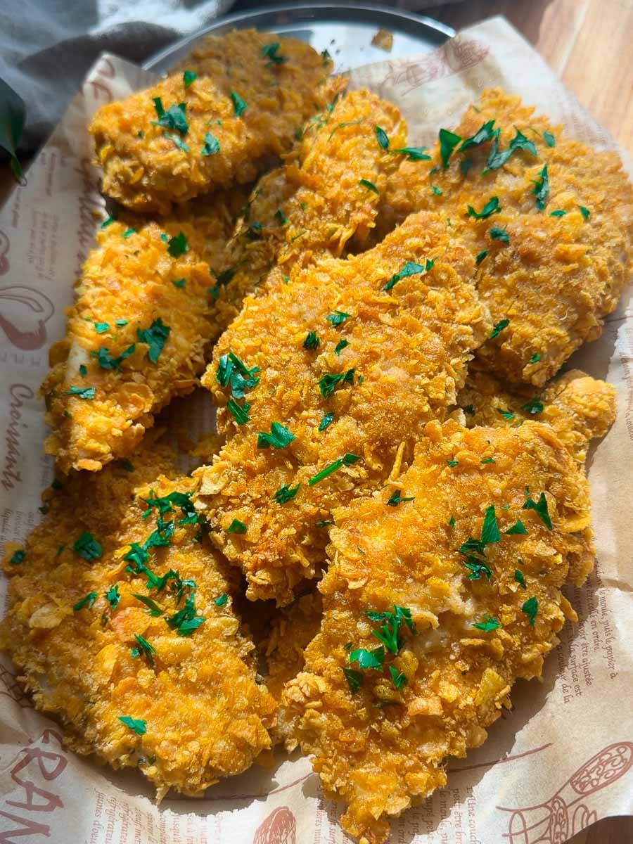 Crispy baked chicken tenders topped with chopped parsley