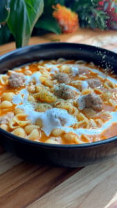 Bowl of nunug Armenian soup with meatballs and labneh drizzle